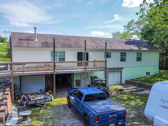 back of house featuring a garage and a wooden deck