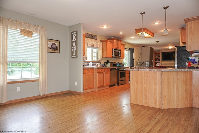 kitchen with light hardwood / wood-style floors, a healthy amount of sunlight, and range