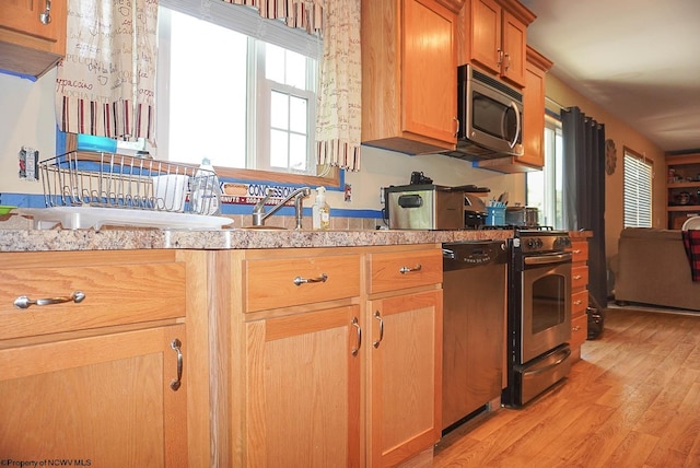 kitchen with stainless steel appliances and light hardwood / wood-style flooring