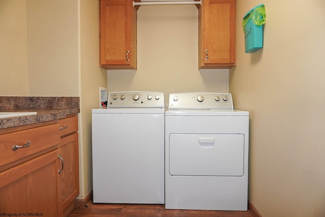 clothes washing area featuring washer and dryer, cabinets, dark hardwood / wood-style flooring, and hookup for a washing machine