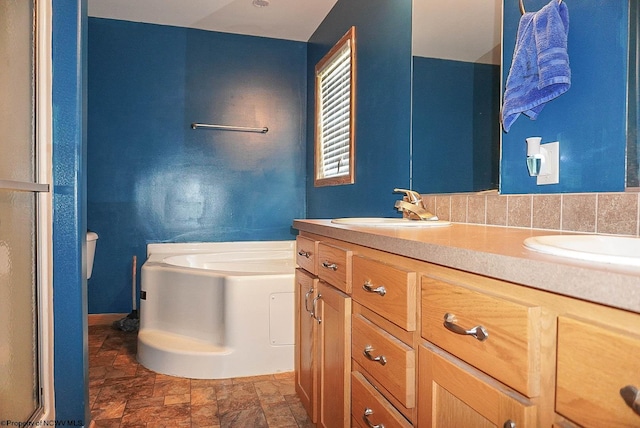 bathroom featuring dual vanity, tile floors, toilet, and a bathtub