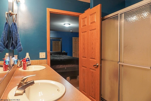 bathroom featuring dual vanity and a shower with door