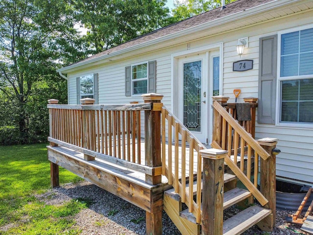 wooden terrace featuring a lawn