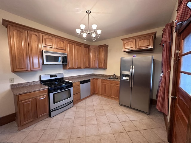 kitchen with appliances with stainless steel finishes, an inviting chandelier, a wealth of natural light, and sink