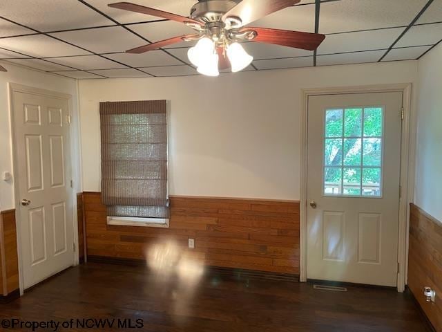 entryway featuring ceiling fan, dark hardwood / wood-style floors, a paneled ceiling, and wooden walls