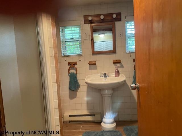 bathroom featuring tasteful backsplash, tile walls, and baseboard heating