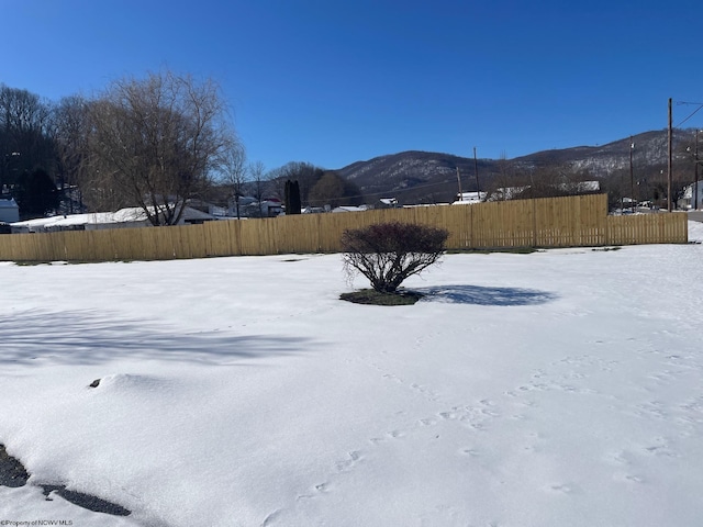 yard layered in snow featuring a mountain view