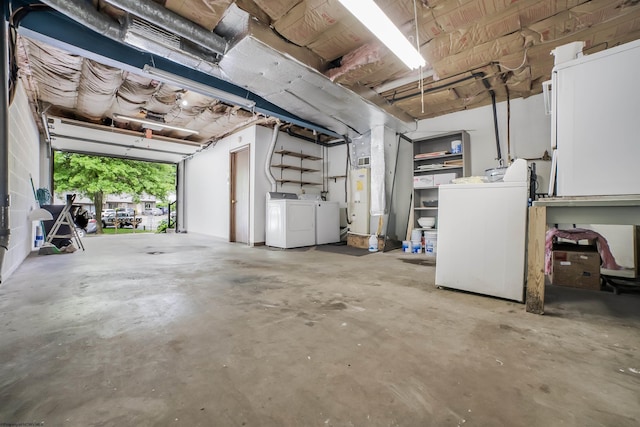 garage featuring gas water heater and washing machine and clothes dryer