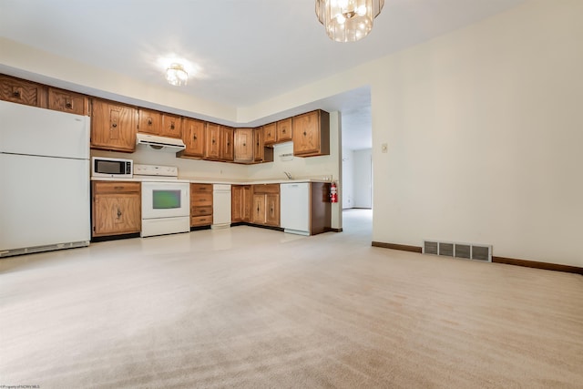 kitchen featuring light colored carpet, a notable chandelier, and white appliances