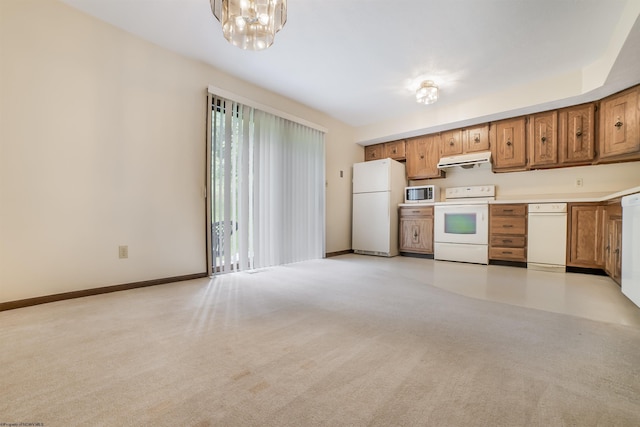 kitchen featuring light carpet, white appliances, and an inviting chandelier