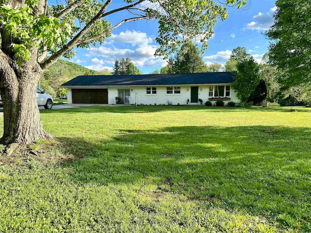 single story home featuring a garage and a front lawn