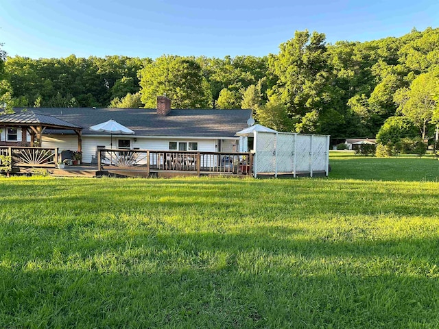 back of property with a lawn and a wooden deck