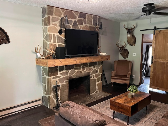 living room featuring a fireplace, ceiling fan, wood-type flooring, baseboard heating, and a textured ceiling