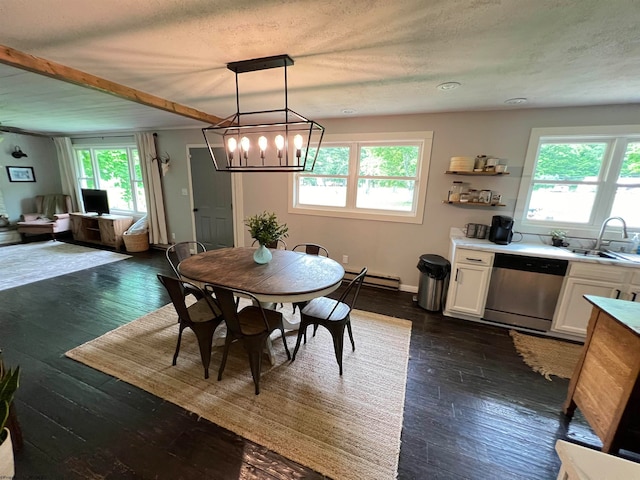 dining area with sink, dark hardwood / wood-style flooring, a wealth of natural light, and an inviting chandelier