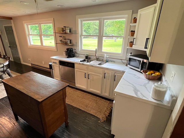 kitchen with appliances with stainless steel finishes, sink, and dark wood-type flooring