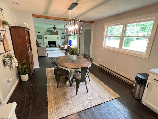 dining space with a baseboard radiator, dark wood-type flooring, a brick fireplace, and ceiling fan