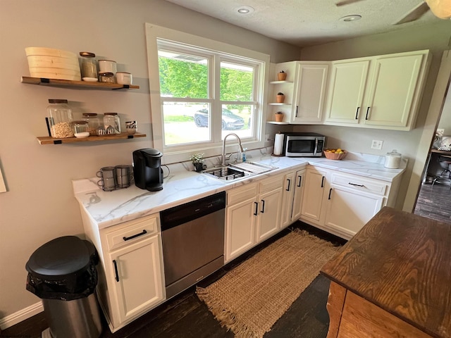 kitchen with dark hardwood / wood-style flooring, light stone counters, sink, white cabinetry, and appliances with stainless steel finishes