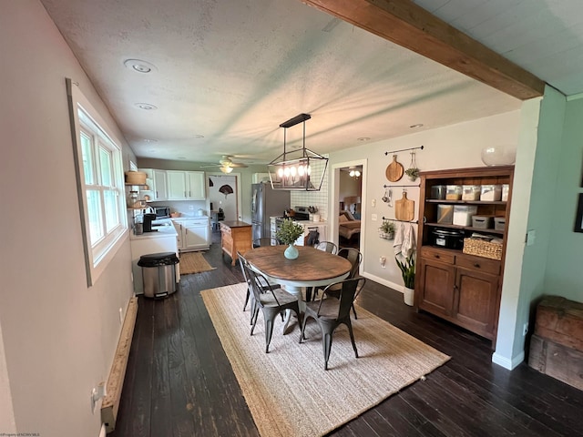 dining area featuring dark hardwood / wood-style floors, beam ceiling, and ceiling fan with notable chandelier