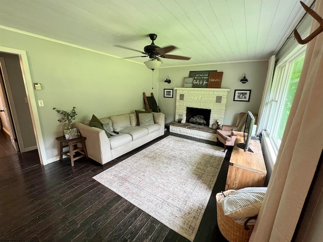 living room with ornamental molding, ceiling fan, dark hardwood / wood-style floors, and a fireplace