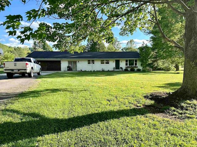 single story home featuring a garage and a front yard