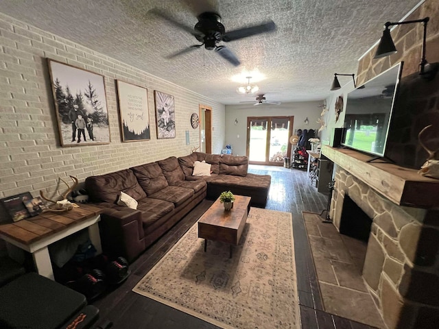 living room featuring a textured ceiling, brick wall, ceiling fan, and dark wood-type flooring