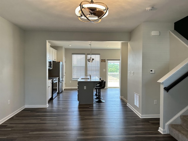 unfurnished dining area featuring sink, dark hardwood / wood-style floors, and a chandelier