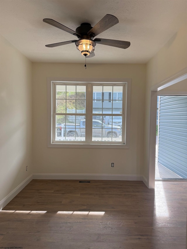 empty room with ceiling fan and dark hardwood / wood-style floors