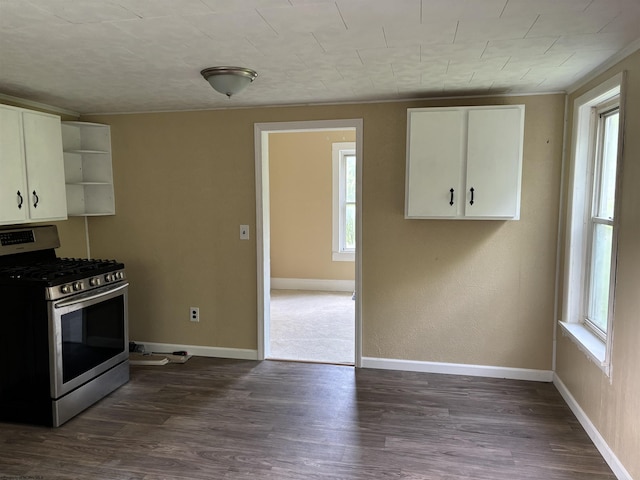 kitchen featuring stainless steel gas range oven, dark hardwood / wood-style flooring, white cabinetry, and a wealth of natural light