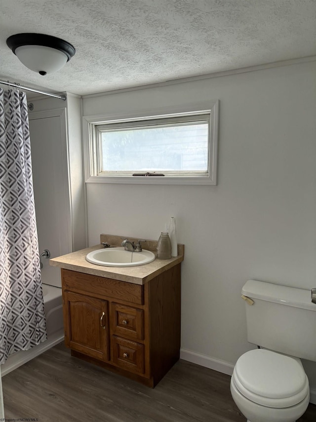 full bathroom with shower / bath combo with shower curtain, hardwood / wood-style floors, vanity, and toilet