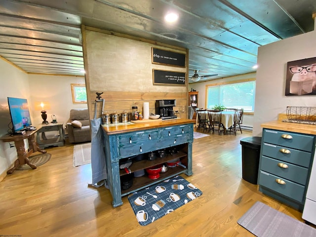 kitchen with ceiling fan, light hardwood / wood-style floors, blue cabinetry, and wooden counters