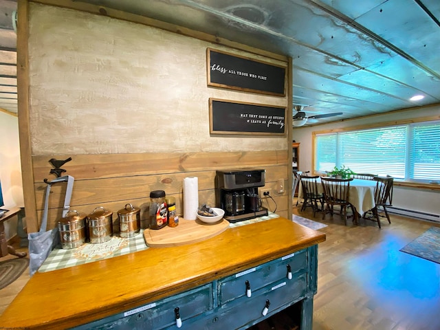 kitchen featuring hardwood / wood-style floors, baseboard heating, blue cabinets, and ceiling fan