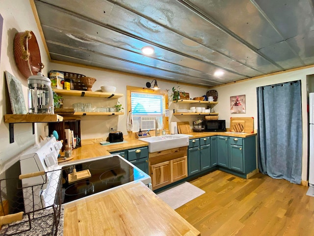 kitchen with wood counters, white stove, cooling unit, sink, and light hardwood / wood-style floors