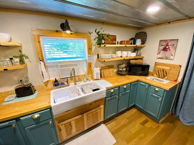 kitchen with wood counters, sink, and light hardwood / wood-style flooring