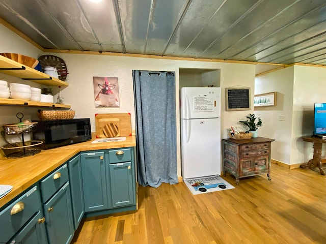 kitchen featuring butcher block counters, white fridge, and light hardwood / wood-style floors