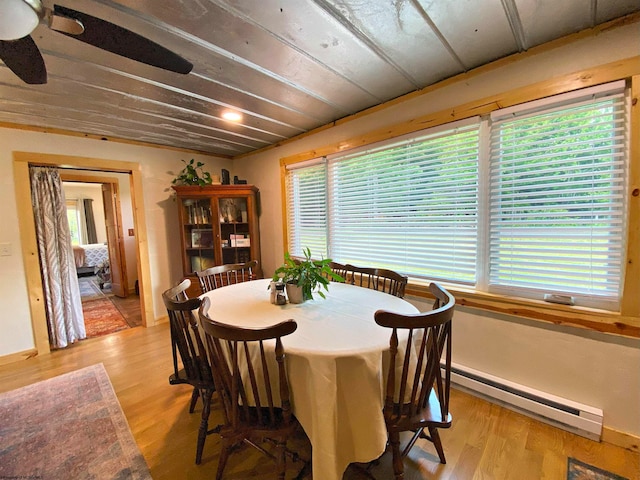 dining room with a baseboard radiator, a wealth of natural light, light hardwood / wood-style floors, and ceiling fan