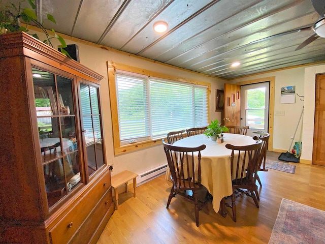 dining area with a baseboard radiator, ceiling fan, and light hardwood / wood-style floors