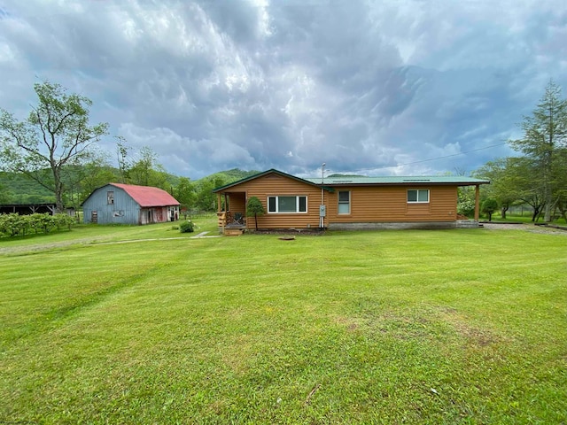 back of house with a yard and an outdoor structure