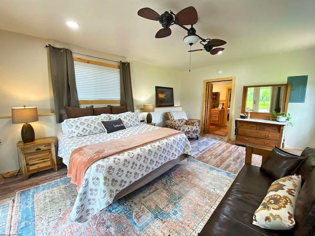 bedroom featuring electric panel, ceiling fan, and hardwood / wood-style floors