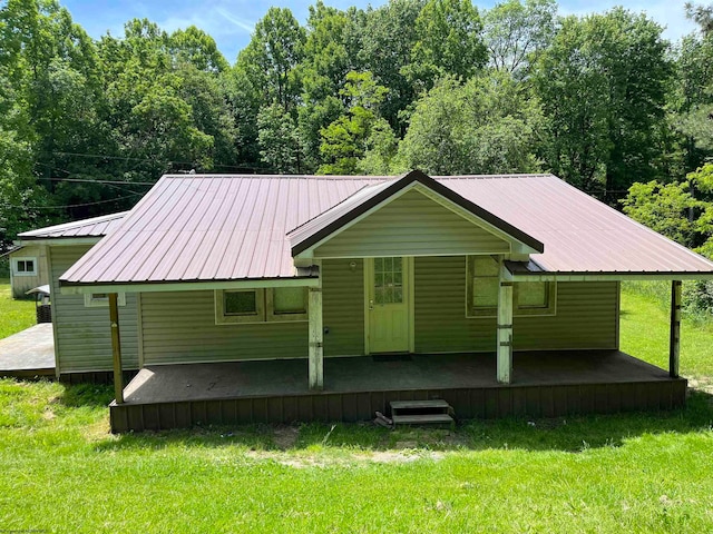 rear view of property featuring a lawn