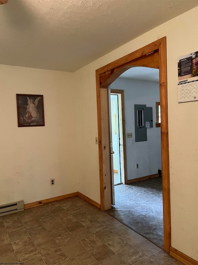 tiled empty room with a baseboard heating unit