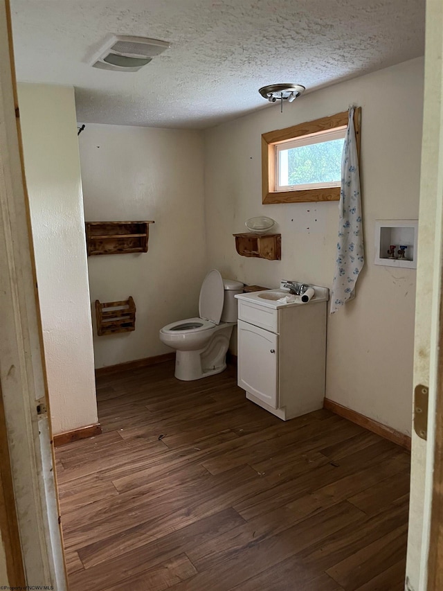 bathroom featuring a textured ceiling, vanity, toilet, and hardwood / wood-style floors