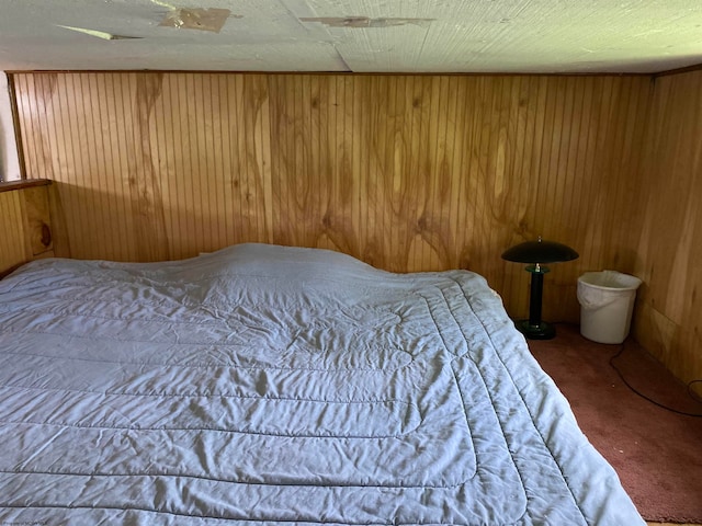 bedroom with wooden walls and carpet floors