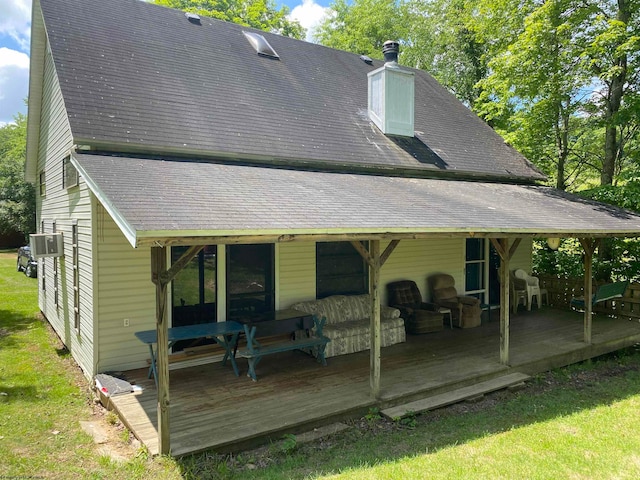 rear view of property with a deck and a lawn