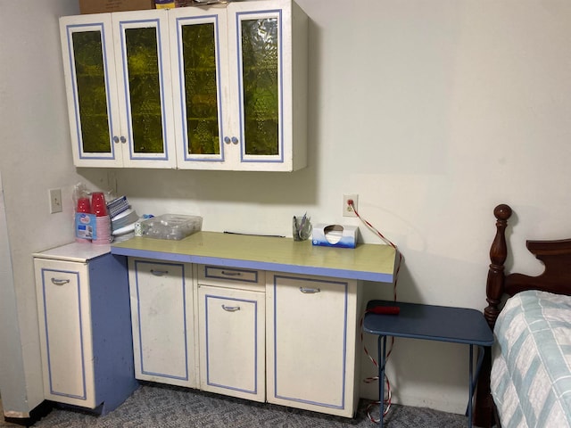 interior space with white cabinets and dark colored carpet