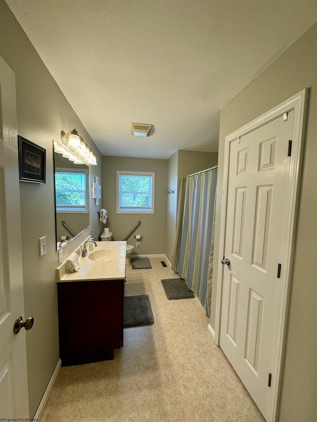 bathroom featuring a shower with shower curtain, a textured ceiling, vanity, and toilet