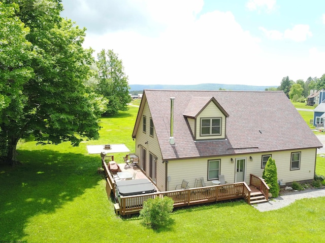 rear view of house with a lawn, a garage, and a wooden deck