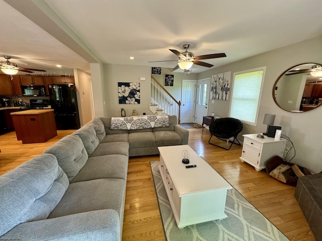 living room with light wood-type flooring and ceiling fan