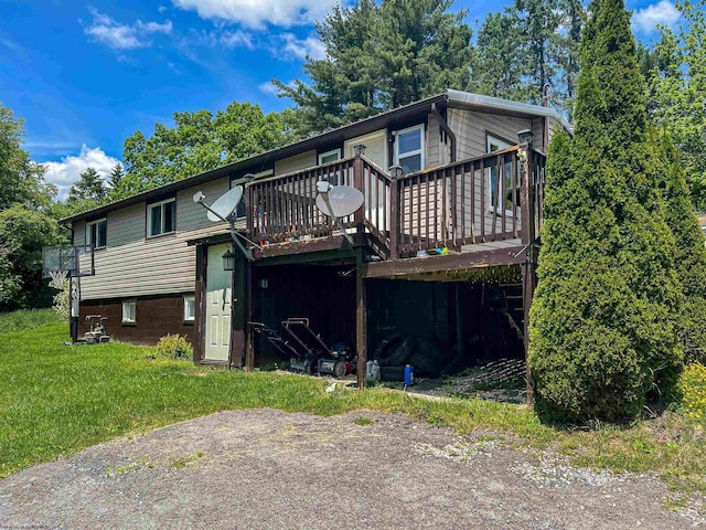 rear view of property with a wooden deck and a yard