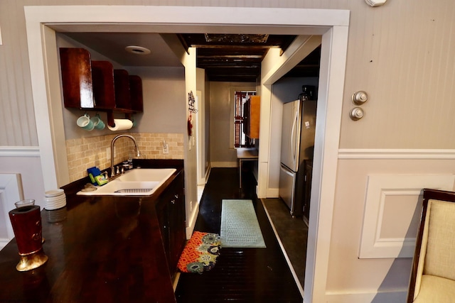 kitchen featuring tasteful backsplash, stainless steel refrigerator, and sink