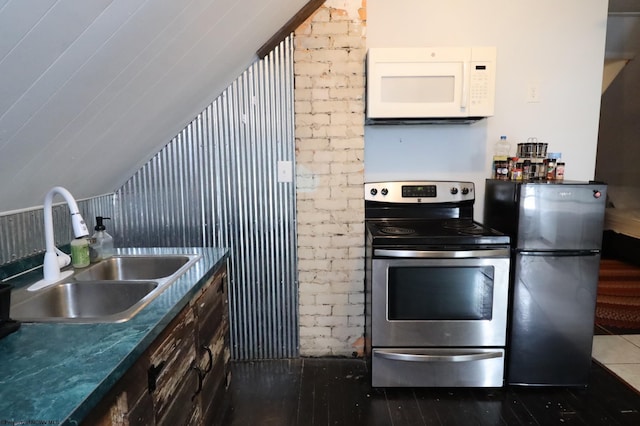 kitchen featuring stainless steel electric range oven, sink, and refrigerator